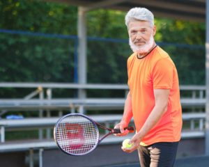 man getting ready to serve tennis ball, tennis court cleaning atlanta